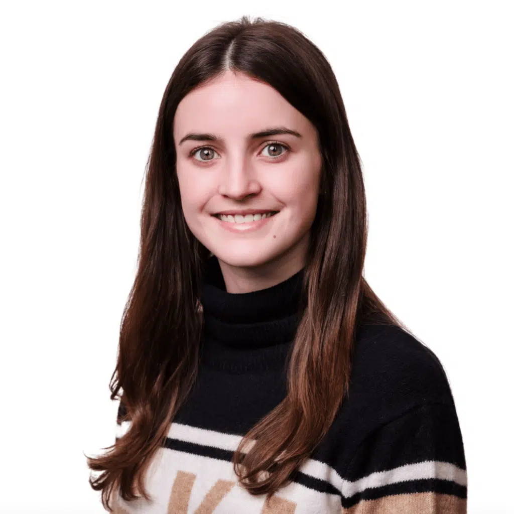 Headshot of Emery Watkins, a tax intern at Jones, Covey, and Company in Washington, NC. Emery assists the team with tax preparation and research, gaining valuable experience in supporting local businesses. She is smiling in a black sweater with beige and white stripes against a white background.